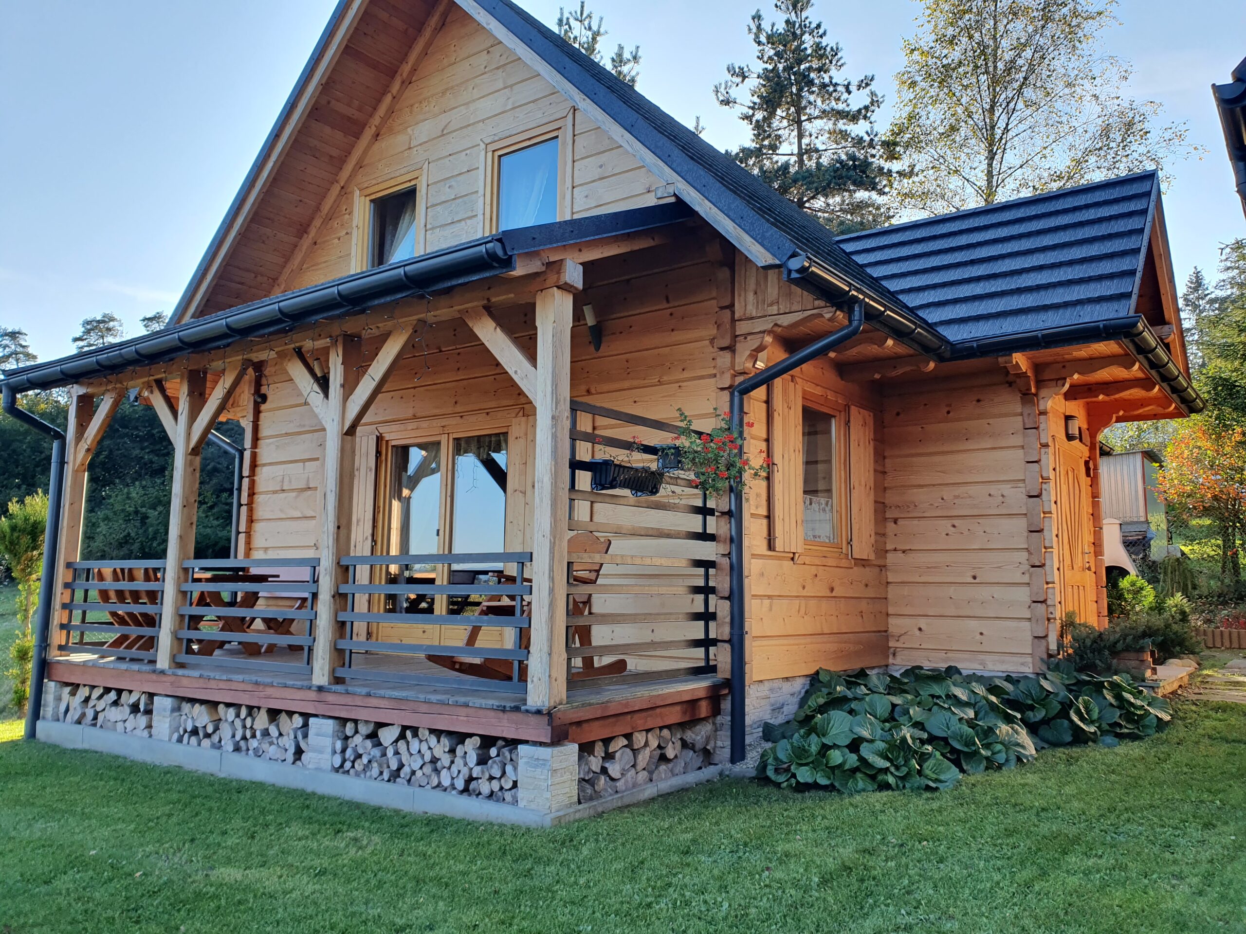 Dom Aleksander tara fotel drewniany bujany i zestaw drewnianych mebli na tarasie